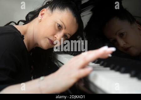 Elegante pianista che suona il pianoforte a coda Foto Stock