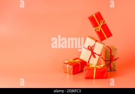 Un sacco di scatole regalo su sfondo rosa. I regali sono avvolti in carta e legati con nastri Foto Stock