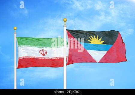 Iran e Antigua e Barbuda due bandiere su flagpoli e. cielo blu nuvoloso Foto Stock