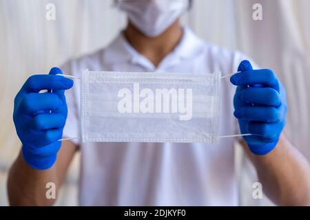 Un uomo con una maschera in mano Foto Stock