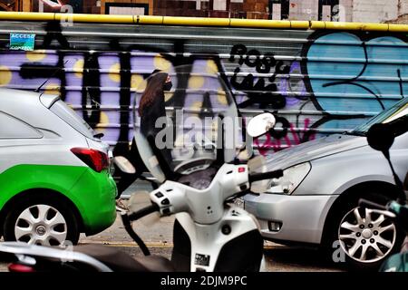 Una giovane donna che passa per i graffiti, Barcellona. Foto Stock