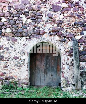 Porta in legno con porta ad arco in una parete in pietra di cava, Alto Adige Foto Stock