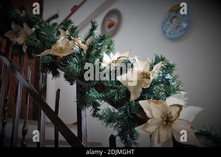 Flay una scala in una casa privata decorata per Natale con ondulazione di pino, luci e fiori bianchi Foto Stock