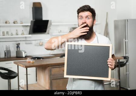 shopping sale and discounts. chef menu in kitchen. look over there. chalkboard for advertising. oh my god. brutal hipster man holding blank board, copy space. job search. there are vacancies. Stock Photo