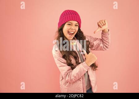 Il mio capo di abbigliamento Preferito. Pronto per l'inverno freddo. Clima freddo. Felice bambina rosa sfondo. Giacca piumino e cappello a maglia per bambini. Shopping invernale. Come vestirsi caldo in inverno. Foto Stock