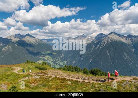 Sabbia a Taufers, Provincia di Bolzano, Alto Adige, Italia. Escursionisti sul sentiero panoramico nella zona escursionistica di Speikboden. Sullo sfondo a sinistra il gruppo Durreck e a destra il gruppo Rieserfern Foto Stock