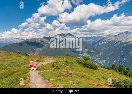 Sabbia a Taufers, Provincia di Bolzano, Alto Adige, Italia. Escursionisti sul sentiero panoramico nella zona escursionistica di Speikboden. Sullo sfondo a sinistra il gruppo Durreck e a destra il gruppo Rieserfern Foto Stock