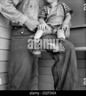 Bambino giovane con i piedi della conca che indossano le spinte fatte in casa all'interno delle scarpe, campo di amministrazione di sicurezza della fattoria per i lavoratori migratori, Farmersville, Contea di Tulare, California, USA, Dorotea Lange, Amministrazione di sicurezza della fattoria degli Stati Uniti, maggio 1939 Foto Stock