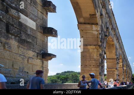 PONR DU GARD, FRANCIA - 17 LUGLIO 2018: Turisti che camminano sul Pont du Gard in un pomeriggio estivo Foto Stock