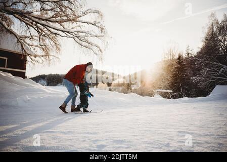 Papà insegnando figlio a sci di fondo in fattoria inverno wonderland Norvegia Foto Stock