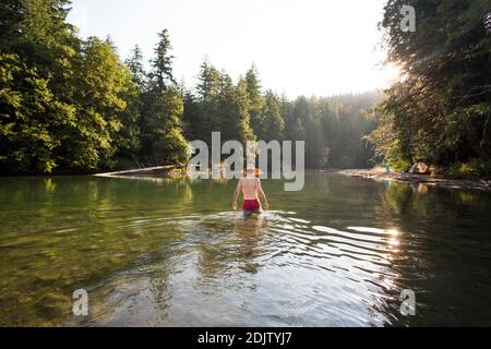 Un giovane si inguira nel fiume Ohanapecosh a Washington. Foto Stock