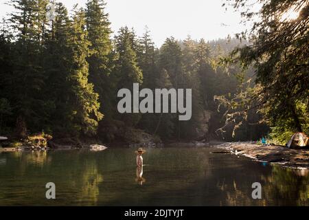 Un giovane si inguira nel fiume Ohanapecosh a Washington. Foto Stock