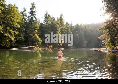 Un giovane si inguira nel fiume Ohanapecosh a Washington. Foto Stock