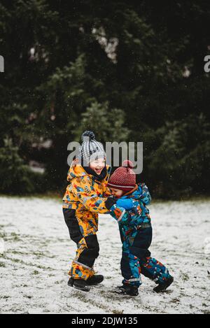 I bambini si divertono all'aperto al parco che gioca sulla neve Giornata invernale Europa Foto Stock