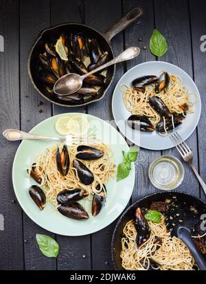 Pasta con cozze stile minimalista. Spaghetti allo scoglio in tegole in ghisa vista dall'alto Foto Stock