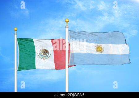 Mexico and Argentina two flags on flagpoles and blue cloudy sky Stock Photo