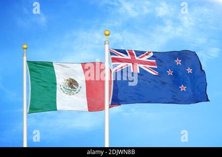 Messico e Nuova Zelanda due bandiere su flagpoli e blu cielo nuvoloso Foto Stock