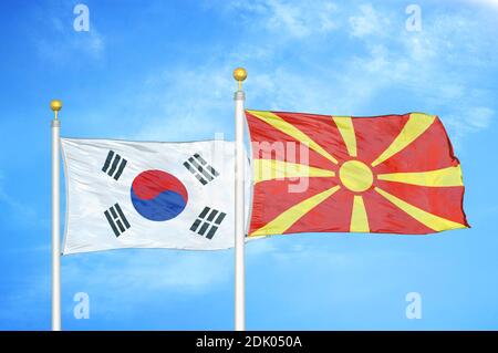 Corea del Sud e Macedonia del Nord due bandiere sui flagpoli e. cielo blu nuvoloso Foto Stock