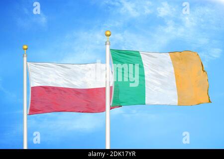 Polonia e Irlanda due bandiere su paletti e blu nuvoloso cielo Foto Stock