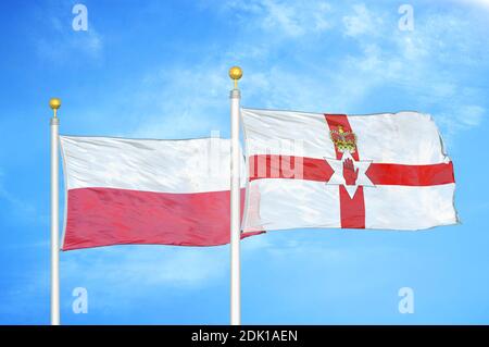 Polonia e Irlanda del Nord due bandiere su flagpoli e blu cielo nuvoloso Foto Stock