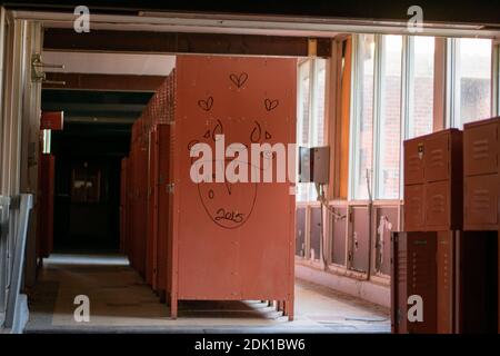Una Locker Room con armadietti rossi in una scuola abbandonata Foto Stock