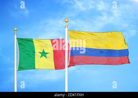 Senegal e Colombia due bandiere su paletti e blu nuvoloso cielo Foto Stock