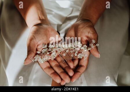 Un colpo ad alto angolo di una persona che tiene una sposa accessorio per capelli Foto Stock