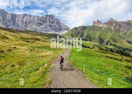 Giovane (22 anni) in bicicletta elettrica lungo un sentiero alpino in Alpe di Susi, Dolomiti, Alto Adige/Südtirol, Italia, Europa Foto Stock