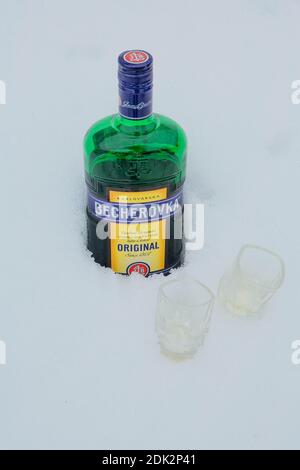 Sheregesh, Russia-14 aprile 2018: Bottiglia di Becherovka con due colpi di neve all'aperto. Becherovka è amaro erboristico prodotto in Karlovy Vary i Foto Stock