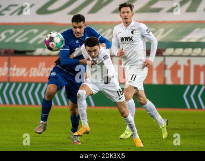 Augusta, Germania. 13 Dicembre 2020. Calcio: Bundesliga, FC Augusta - FC Schalke 04, 11° incontro nella WWK-Arena. Ruben Vargas (M) di Augusta e Ozan Kabak di Schalke lottano per la palla, Michael Gregoritsch sulla destra. Credito: Stefan Puchner/dpa - NOTA IMPORTANTE: In conformità con le norme del DFL Deutsche Fußball Liga e del DFB Deutscher Fußball-Bund, è vietato sfruttare o sfruttare nello stadio e/o nel gioco le fotografie scattate sotto forma di sequenze di immagini e/o serie di foto di tipo video./dpa/Alamy Live News Foto Stock