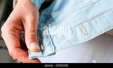 Dettaglio di una giacca in denim. Mostra un cappotto di jeans blu chiaro. Foto Stock