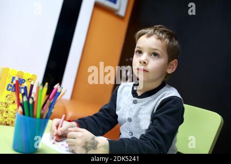 Ritratto di un disegno figlio al tavolo Foto Stock