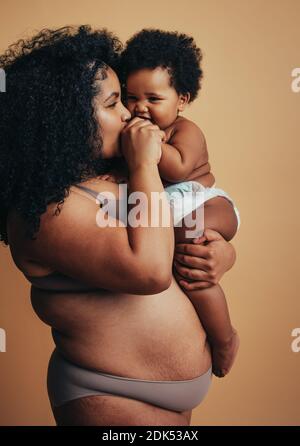 Madre e bambino sani. Donna con una figura dopo la nascita. Segni di stiramento sulla pancia. Foto Stock