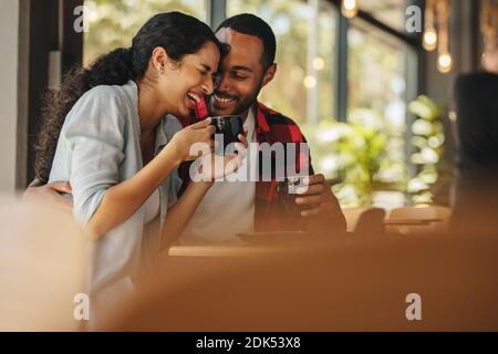 Una coppia parla di una tazza di caffè al bar. Uomo e donna seduti al bar che conversano mentre si fa un caffè. Foto Stock