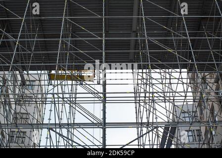 Cantiere dell'edificio. Ampia impalcatura che fornisce piattaforme per lavori in corso su un alto edificio in costruzione con ponteggi. Foto Stock