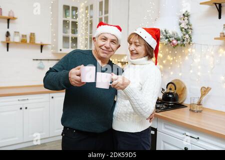 Happy mature couple having breakfast on Christmas kitchen at home Stock Photo