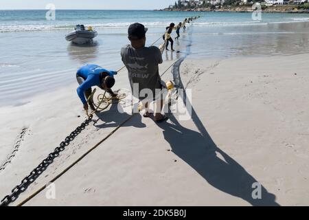 Un equipaggio di avvistatori di squalo dispiega una barriera netta di esclusione dello squalo a Fish Hoek Beach, False Bay, Città del Capo, Sud Africa. Protezione da bacon. Turismo. Foto Stock