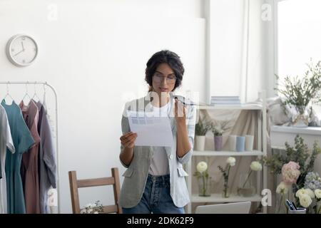 Giovane donna designer che cerca informazioni in internet utilizzando assistente virtuale Foto Stock