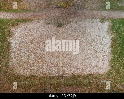 Aereo top down drone colpo di spiaggia deserta pallavolo giocare campo in zona ricreativa locale in autunno con foglie cadute coprendo la sabbia Foto Stock