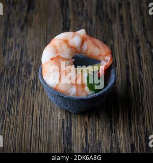 ciotola di antipasto con gamberi bolliti su tavola di legno Foto Stock