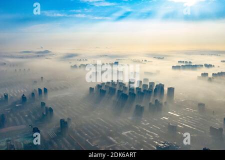 Le nuvole dell'avvento scorrono lentamente tra gli edifici urbani, che si profilano come una zona fieristica nella città di Shijiazhuang, provincia di Hebei, nella Cina settentrionale, il 12 dicembre Foto Stock