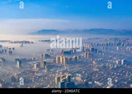 Le nuvole dell'avvento scorrono lentamente tra gli edifici urbani, che si profilano come una zona fieristica nella città di Shijiazhuang, provincia di Hebei, nella Cina settentrionale, il 12 dicembre Foto Stock