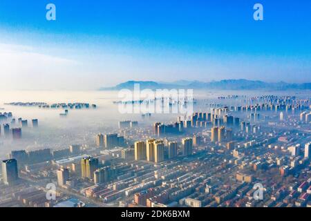 Le nuvole dell'avvento scorrono lentamente tra gli edifici urbani, che si profilano come una zona fieristica nella città di Shijiazhuang, provincia di Hebei, nella Cina settentrionale, il 12 dicembre Foto Stock