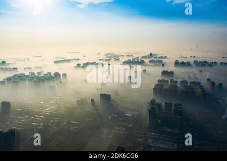 Le nuvole dell'avvento scorrono lentamente tra gli edifici urbani, che si profilano come una zona fieristica nella città di Shijiazhuang, provincia di Hebei, nella Cina settentrionale, il 12 dicembre Foto Stock