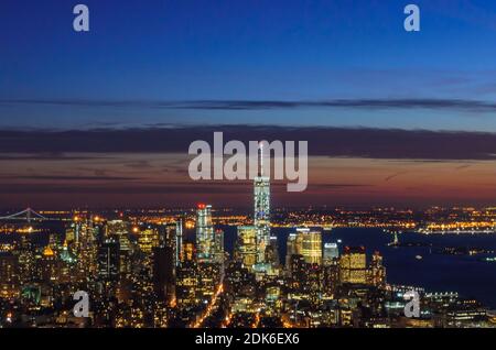 Vista panoramica mozzafiato e aerea di Manhattan, New York City di notte. Edifici illuminati dopo il tramonto. Bellissimi colori Crimson nel cielo. Foto Stock