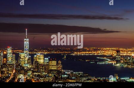 Vista panoramica mozzafiato e aerea di Manhattan, New York City di notte. Edifici illuminati dopo il tramonto. Bellissimi colori Crimson nel cielo. Foto Stock