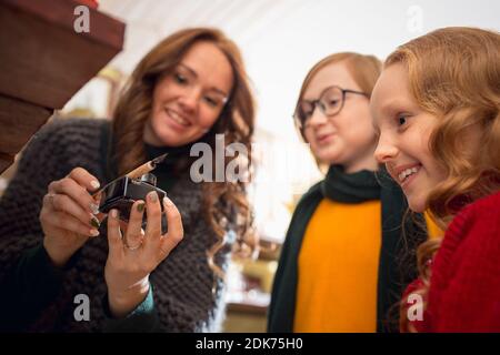 Inkwell. Famiglia allegra, madre e bambini in cerca di decorazione domestica e regali di festa nel negozio di famiglia. Eleganti oggetti retrò per saluti o design. Ristrutturazione degli interni, festeggiando il tempo. Foto Stock