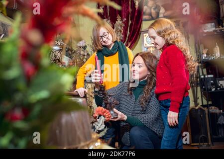 Candle. Cheerful family, mother and kids looking for home decoration and holiday's gifts in household store. Stylish retro things for greetings or design. Interior renovation, celebrating time. Stock Photo