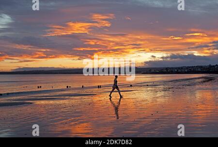 Portobello, Edimburgo, Scozia, Regno Unito. 15 dicembre 2020. Il cielo di Fiery all'alba per questa nuotatrice femminile di acqua fredda che lascia il Firth of Forth. Credit: Arch White/Alamy Live News. Foto Stock