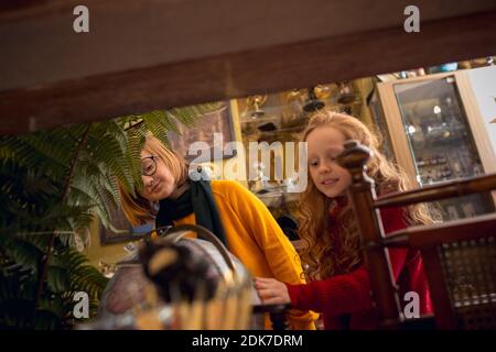 Globo. Famiglia allegra, sorella e fratello in cerca di decorazioni per la casa e regali per le vacanze nel negozio di casa. Eleganti oggetti retrò per saluti o design. Ristrutturazione degli interni, festeggiando il tempo. Foto Stock